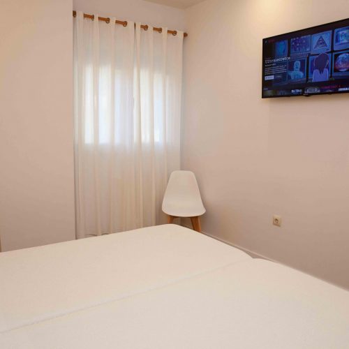 cama y televisión en la pensión Albergue O Burgo en O Pino